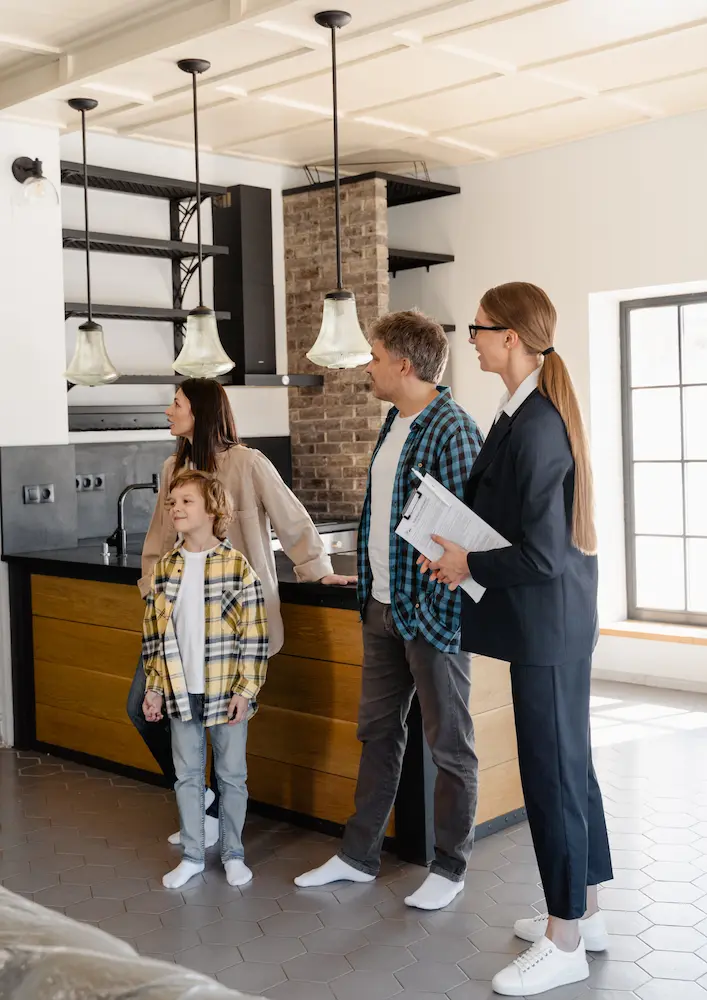 Visite de maison avec des acheteurs potentiels, illustrant l'atmosphère accueillante